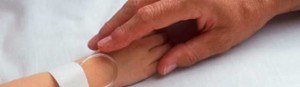 Adult holding sick child's hand